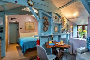 Un dormitorio con una cama y una mesa en una habitación. en Finest Retreats - Fishermans Cottage, en Tintagel