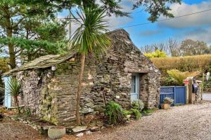 una casa de piedra con una palmera en la parte superior en Finest Retreats - Fishermans Cottage, en Tintagel