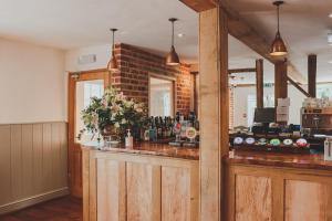 a bar in a room with a brick wall at The Red Lion in East Bergholt