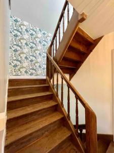 eine Holztreppe in einem Zimmer mit Tapete in der Unterkunft Gîte Le Rucher de Saint Florent - DABNB in Limoges