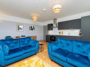 a living room with two blue couches and a kitchen at Pass the Keys Stunning 2 bed retreat in the heart of Bath in Bath