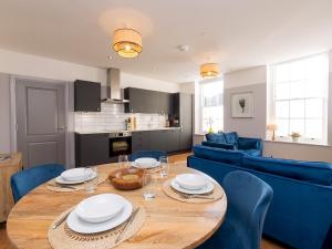 a kitchen and living room with a wooden table and blue chairs at Pass the Keys Stunning 2 bed retreat in the heart of Bath in Bath