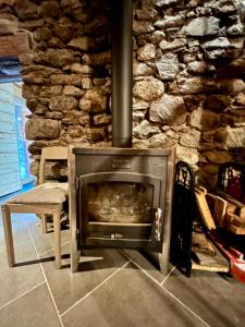 een stenen open haard in een kamer met een stenen muur bij Chalet La Léchère in Valmeinier