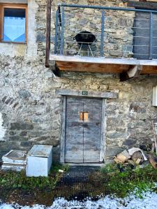 a stone building with a door and a grill at Chalet La Léchère in Valmeinier
