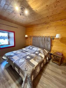 una camera con un letto in una baita di tronchi di Chalet La Léchère a Valmeinier