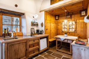 eine Küche mit Holzschränken, einer Spüle und einem Tisch in der Unterkunft Historisches Apartment Duregghof in Jenesien