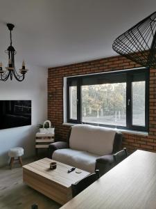 a living room with a couch and a large window at ForestView Dream Apartment in Bucharest