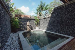 basen w ceglanej ścianie z fontanną w obiekcie Kishi-Kishi ArtVilla w mieście Blahbatu