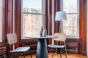 a table and chairs in a room with windows at Boston Studio on Newbury w A shopping dining BOS-600 in Boston