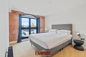 1 dormitorio con 1 cama grande y pared de ladrillo en Stylish 2 Bed Apartment Burton On Trent, en Burton upon Trent