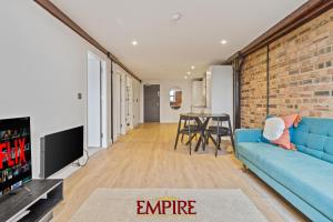 - un salon avec un canapé bleu et un mur en briques dans l'établissement Stylish 2 Bed Apartment Burton On Trent, à Burton-on-Trent