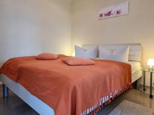 een slaapkamer met een bed met oranje lakens en kussens bij Ferienhaus "Zum Kreideblick" in Sassnitz