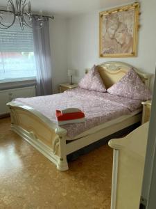 una camera da letto con un grande letto con cuscini rosa di Herz der Weinberge a Gemmrigheim