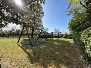 a park with a swing set in the grass at Chalet Garda in Peschiera del Garda