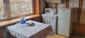 a small kitchen with a table and a refrigerator at Hostel 4 in Šiauliai