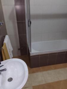 La salle de bains est pourvue d'un lavabo, d'une douche et d'une baignoire. dans l'établissement Residencial Aeroporto, à São Tomé