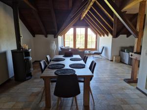 a dining room with a wooden table and chairs at Auberge du Peu-Péquignot in Le Noirmont