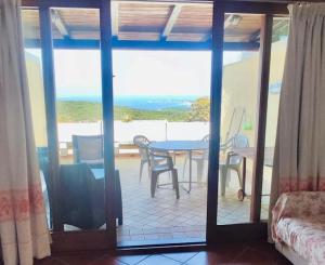 Cette chambre dispose d'une table et offre une vue sur l'océan. dans l'établissement Superior apartments in Residence in Cugnana Verde, à Cugnana Verde
