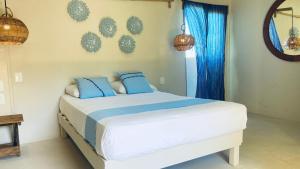 um quarto com uma cama grande e almofadas azuis em Isabella Boutique Hotel em Playa del Carmen