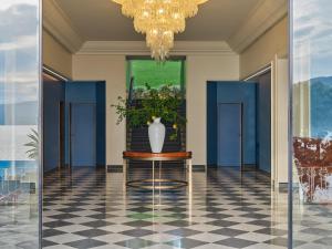 un vase sur une table dans un couloir avec des portes bleues dans l'établissement Grand Hotel Miramare, à Santa Margherita Ligure