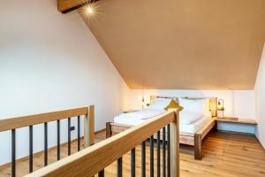 a bedroom with a bed and a staircase at Rotwandterhof Wohnung Bienenstock in Barbiano