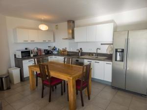 een keuken met een houten tafel en een koelkast bij Bel Appartement avec Terrasse et Clim in Montpellier +8 foto's