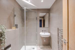a bathroom with a glass shower and a sink at Sweet Dreams - Farringdon - by Frankie Says in London