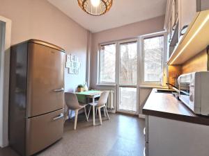 una cucina con frigorifero e tavolo con sedie di Beautifully Decorated Functional Apartment a Sofia