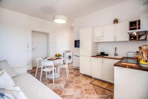 馬薩盧布倫塞的住宿－Suite Solatia，一间厨房,内设白色橱柜和一张桌子
