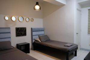 リパにあるLuxeCara Guest Houseのベッド、ベンチ、鏡が備わる客室です。