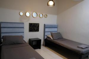 リパにあるLuxeCara Guest Houseのベッド2台と壁掛け鏡が備わる客室です。