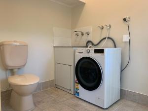 a washing machine in a bathroom with a toilet at Eastwood Central, Walk to Station & Shops, Drive to Olympic in Sydney