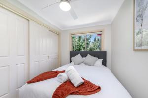 a bedroom with a white bed with towels on it at Eastwood Central, Walk to Station & Shops, Drive to Olympic in Sydney