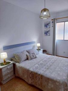 1 dormitorio con 1 cama grande y 2 lámparas en las mesas en Playa Chica House Fuerteventura, en Puerto del Rosario