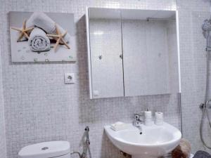 a bathroom with a sink and a toilet and a mirror at Playa Chica House Fuerteventura in Puerto del Rosario