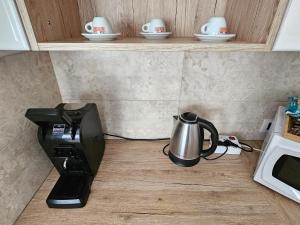 Una cafetera con tetera al lado de un microondas en Maremè Guest House Ostia, en Lido di Ostia