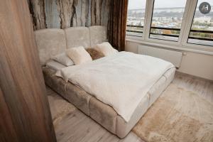 a bed in a room with a large window at AH Albelli II in Košice