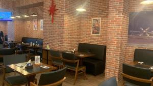 a restaurant with tables and chairs and a brick wall at Quarto em hotel pertinho do aeroporto/ Congonhas in São Paulo