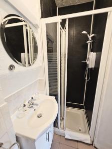 a bathroom with a sink and a shower with a mirror at The Glenbeigh Hotel in Glenbeigh