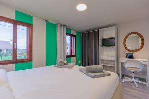 1 dormitorio con cama blanca y espejo en 5 min dal centro - Ca'Lea - Motta di Livenza, en Motta di Livenza