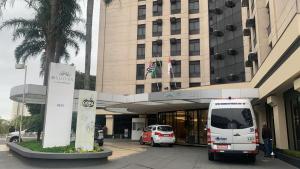 un autobús blanco estacionado frente a un edificio en Quarto em hotel pertinho do aeroporto/ Congonhas en São Paulo