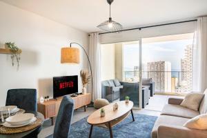 a living room with a couch and a tv at 5mn Monaco - Terrasse - Vue mer - Parking - BD in Beausoleil