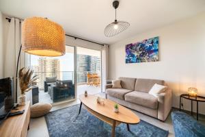 a living room with a couch and a table at 5mn Monaco - Terrasse - Vue mer - Parking - BD in Beausoleil +27 photos