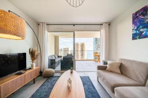a living room with a couch and a tv at 5mn Monaco - Terrasse - Vue mer - Parking - BD in Beausoleil