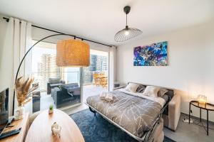 a bedroom with a bed and a living room at 5mn Monaco - Terrasse - Vue mer - Parking - BD in Beausoleil