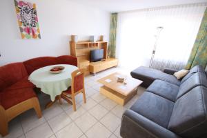 ein Wohnzimmer mit einem Sofa und einem Tisch in der Unterkunft Appartements Biedermeier in Bad Krozingen