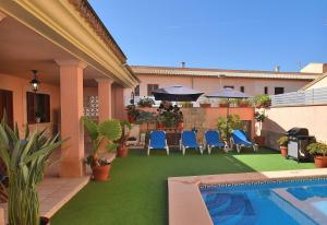 un patio con sillas azules y una piscina en Villa Cas Barber 226 by Mallorca Charme, en Muro