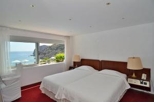 ein Schlafzimmer mit einem großen Bett und einem großen Fenster in der Unterkunft Istron Bay Hotel in Istro