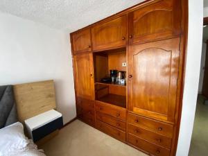 a wooden cabinet in a room with a bed at ERY total confort Pasto apto in Pasto