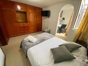 a bedroom with a large bed and a dresser at ERY total confort Pasto apto in Pasto